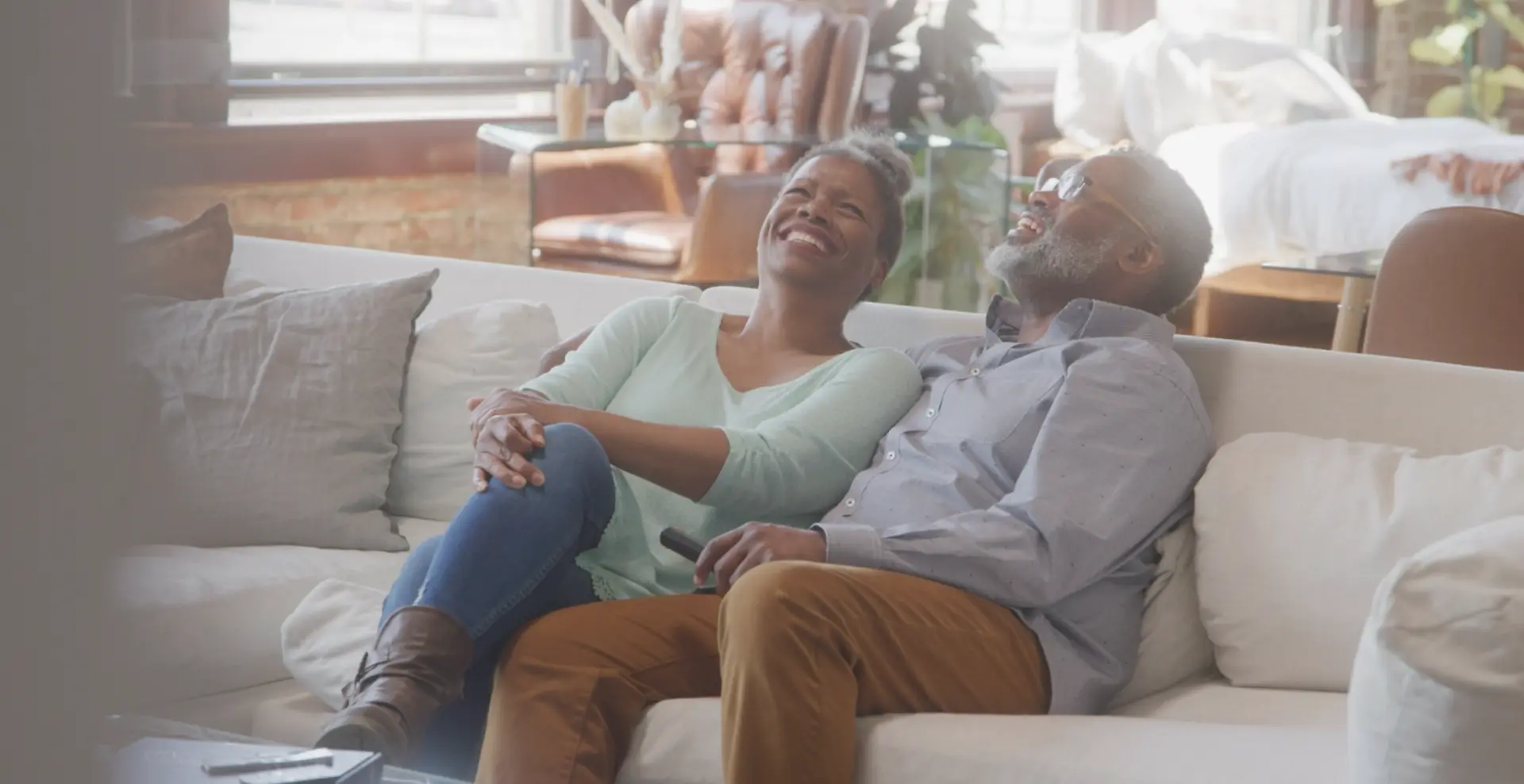 A couple laughing and relaxing together on a comfortable sofa