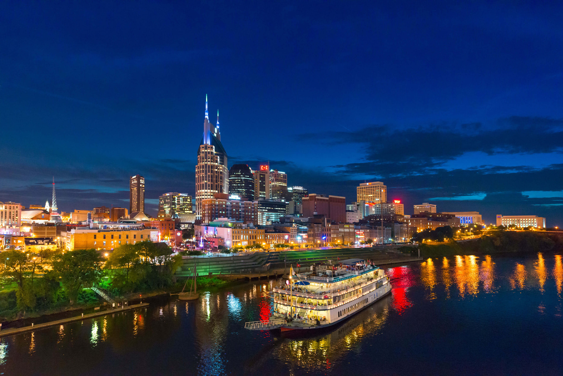 Nashville skyline at night with the Cumberland River and a riverboat